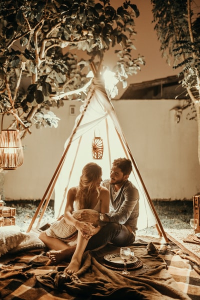 一对夫妇坐在有灯光的tepee小屋里